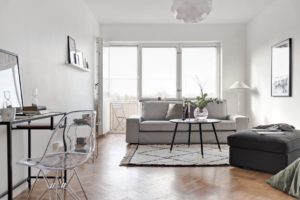 vardagsrum med matta och grå soffa