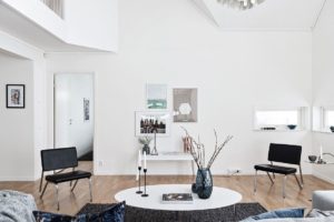 foto på vitt soffbord med vas och vitt vägg med konst