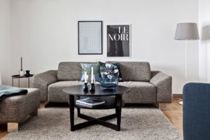 grå soffa med svart soffbord framför
