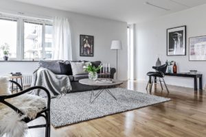 Ljust vardagsrum med en grå soffa