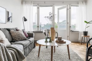 inredning grå soffa vita gardiner parkettgolv